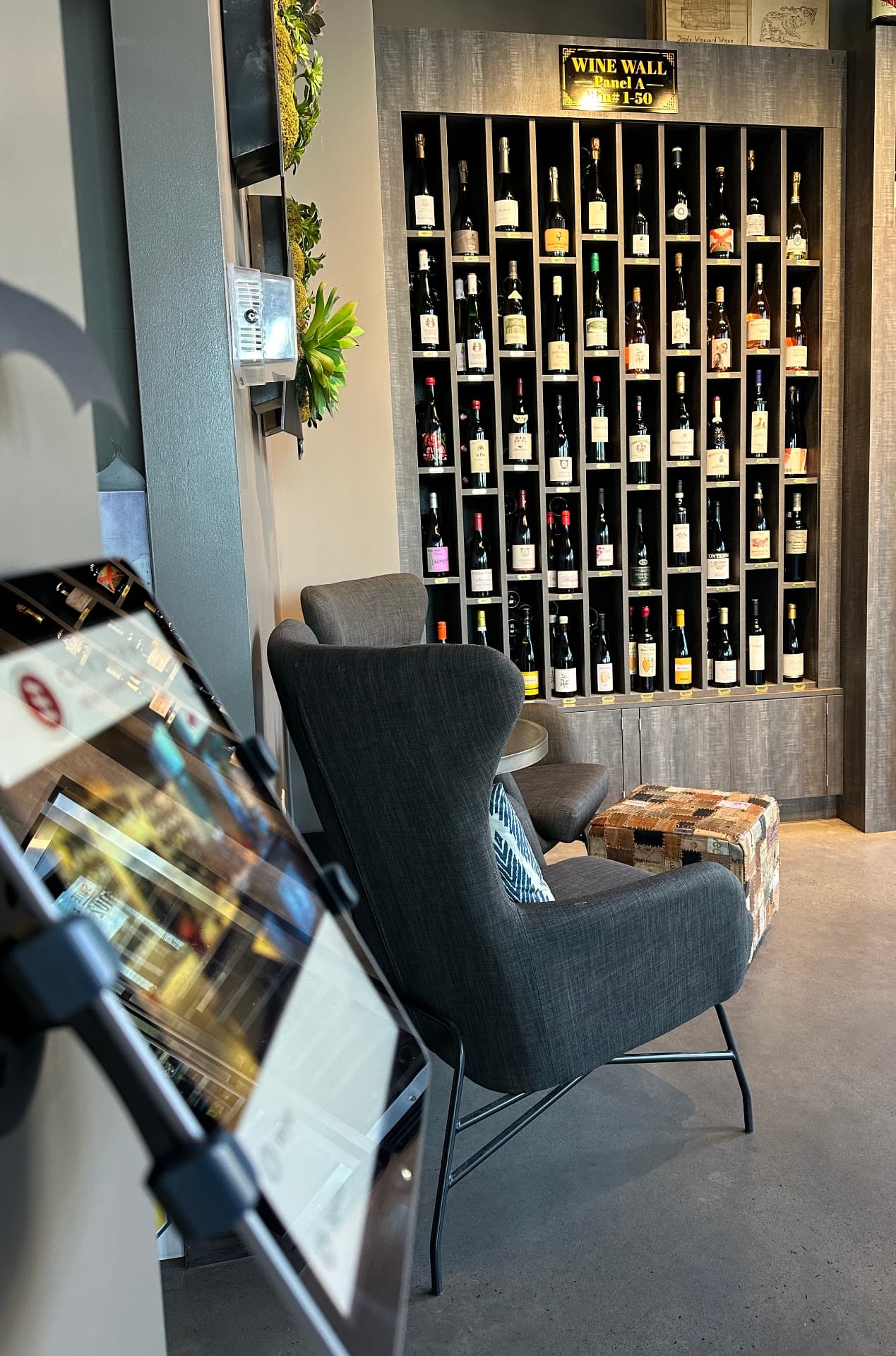 The Wine Wall at Corkscrew Kingsley with a lounge chair and iPad wine catalog